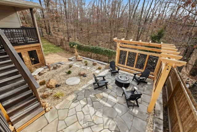 Relaxing outdoor patio with fire pit, seating, and wooden pergola at The Witherby Woodland Retreat.