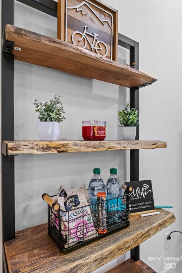 Rustic wooden shelves with decorative bike art and beverages at Black Bear Cabin, Bella Vista.