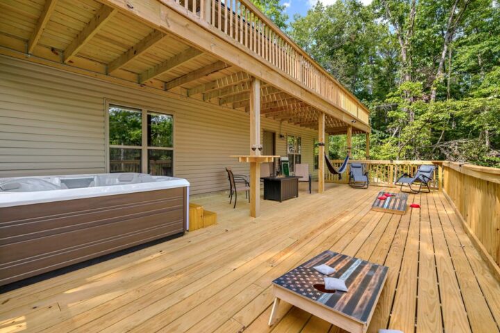 Spacious outdoor deck at OZ Adventure Retreat with hot tub, hammock, and seating area near Back 40 T.