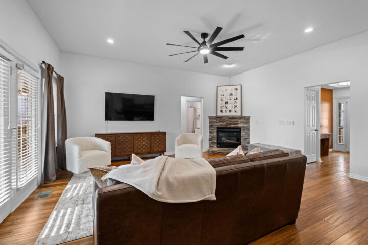 Cozy living room with modern decor, fireplace, and large windows in The Witherby Woodland Retreat.