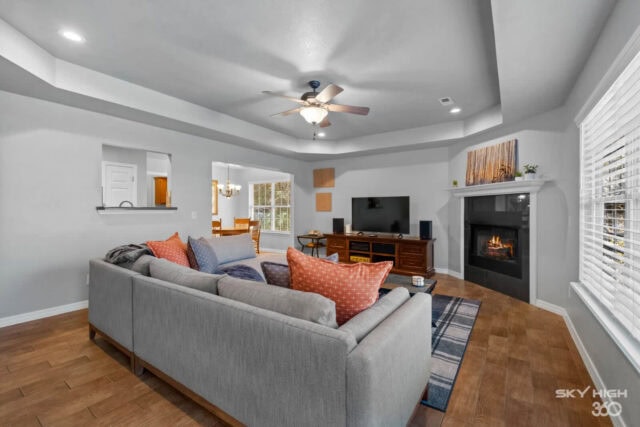 Bright, modern living room with gray sofa, fireplace, and large windows in a cozy vacation rental.