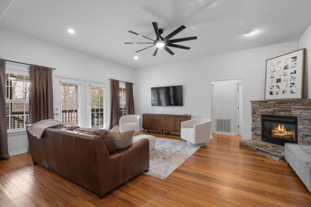 Cozy living room with modern decor, fireplace, and large windows at The Witherby Woodland Retreat.