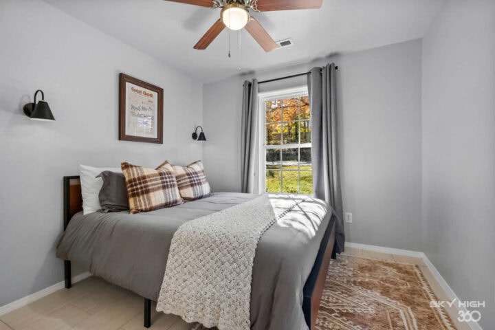 Cozy bedroom with gray walls, white bedding, and natural light in Bella Vista retreat.