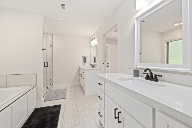 Modern white bathroom with double vanity and walk-in shower near Back 40 Trails.