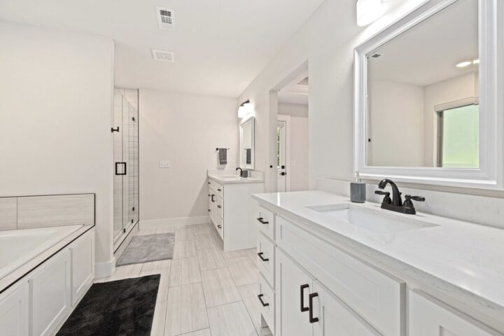 Modern white bathroom with double vanity and walk-in shower near Back 40 Trails.