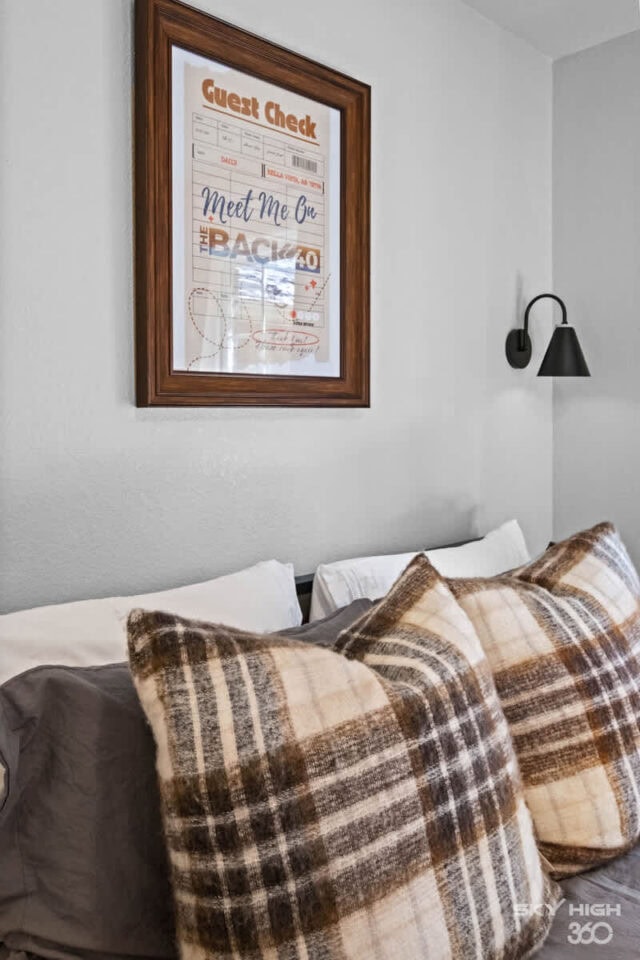 A comfortable guest room with cozy plaid pillows and a guest check poster, perfect for relaxing at B.