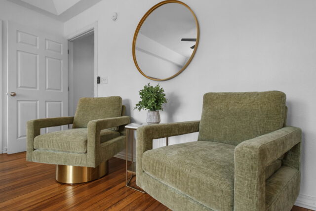 Cozy living room with green armchairs and modern decor at Bella Vista Vacation Rental near Back 40 T.