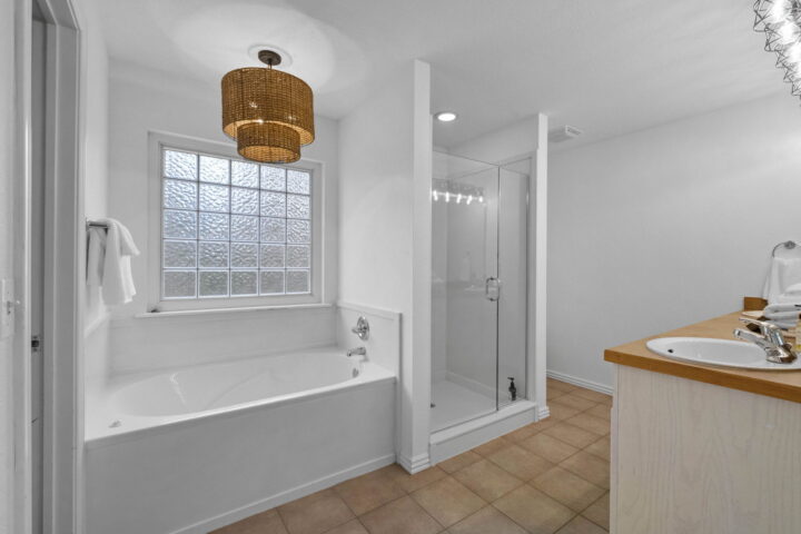 A detailed bathroom with a bathtub, glass shower, and vanity in a cozy woodland retreat.