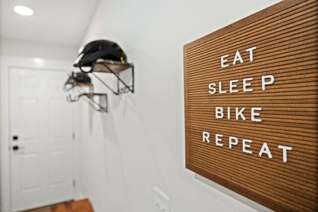 Modern interior with bike helmet storage and motivational "Eat Sleep Bike Repeat" sign in Oz Adventu.