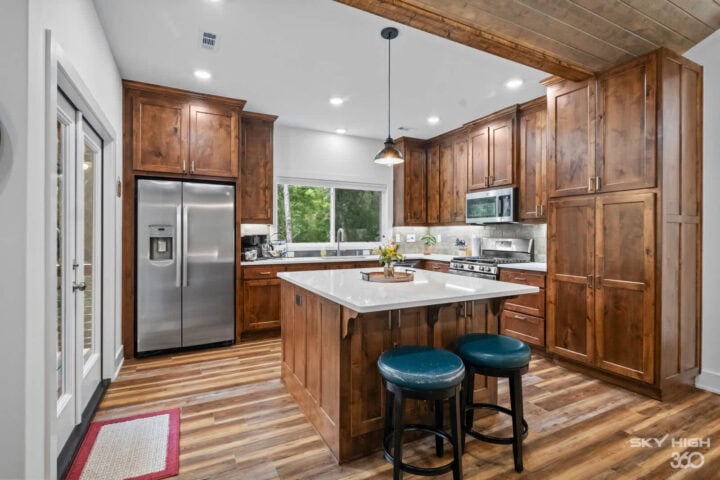 Modern kitchen with wooden cabinets and stainless steel appliances in Black Bear Cabin rental.