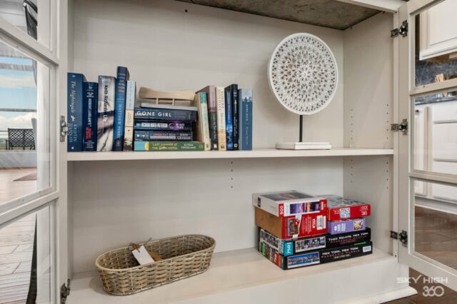 Bright white bookshelf with books and board games in a cozy vacation rental home.