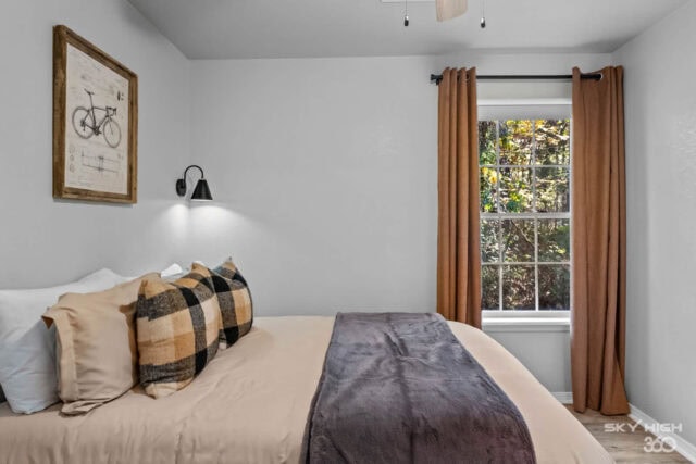 A cozy bedroom with a large window and earthy decor in a rustic vacation rental.