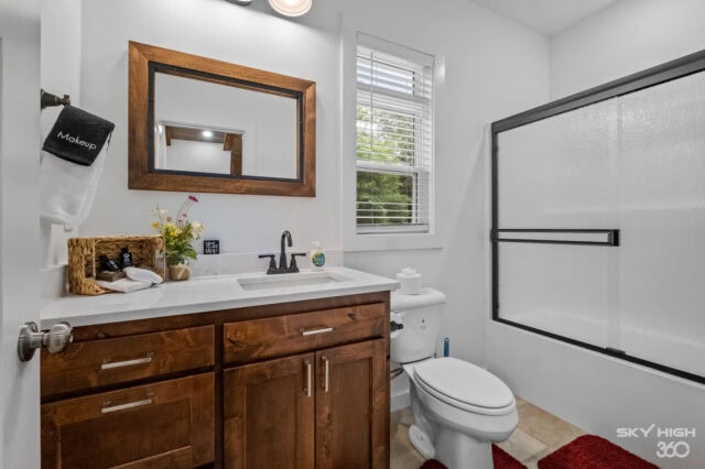 Modern bathroom with wooden vanity, mirror, and shower in Black Bear Cabin rental.