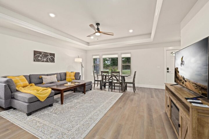Bright living room with large windows, modern decor, and cozy seating in Bella Vista vacation rental.