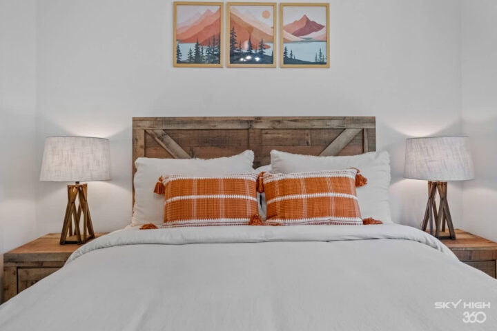 Cozy bedroom in Black Bear Cabin with rustic wooden headboard and mountain artwork, perfect for a Ba.