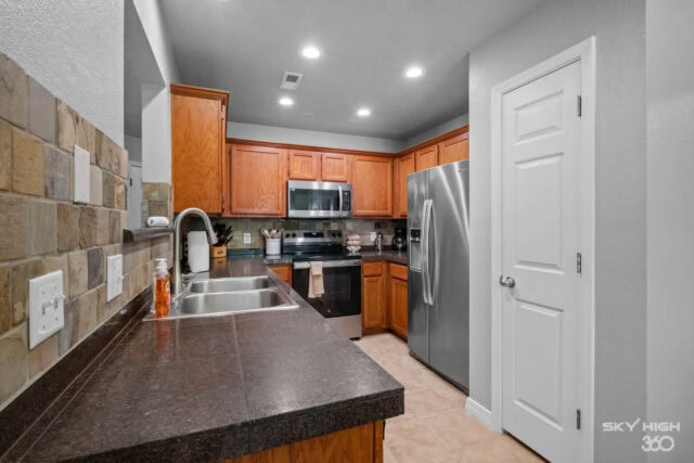 Modern kitchen with stainless steel appliances and wooden cabinets in a cozy vacation rental.