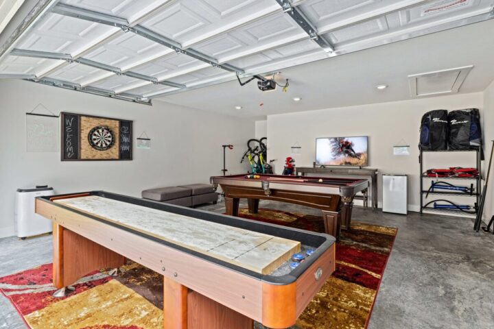 Game room with pool table, dartboard, and TV in OZ Adventure Retreat near Back 40 Trails.