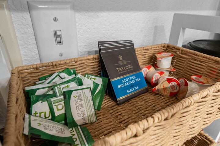 Fresh tea bags and coffee creamer in a wicker basket at The Witherby Woodland Retreat, Bella Vista V.
