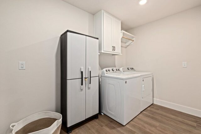 Modern laundry room with refrigerator and washer in Bella Vista vacation rental near Back 40 Trails.