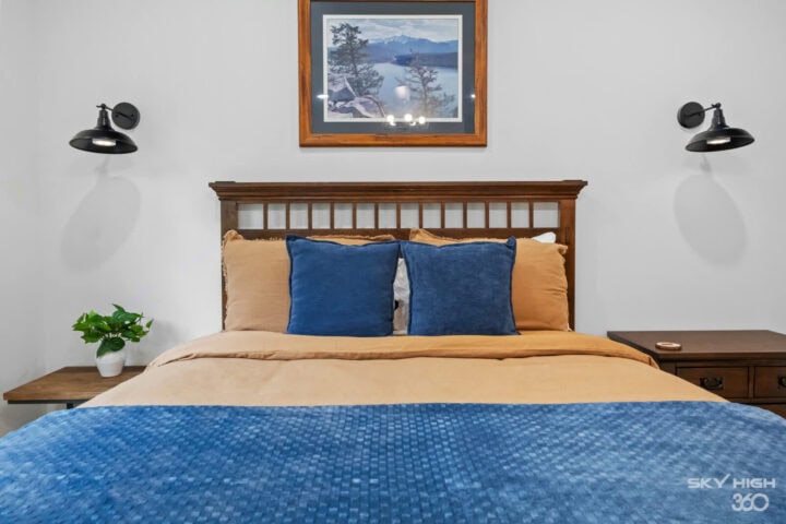 Black Bear Cabin bedroom with cozy bed, blue accents, and rustic decor in Bella Vista vacation renta.