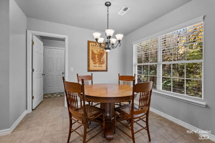 Cozy dining area with large windows and wooden furniture in a mountain retreat setting.