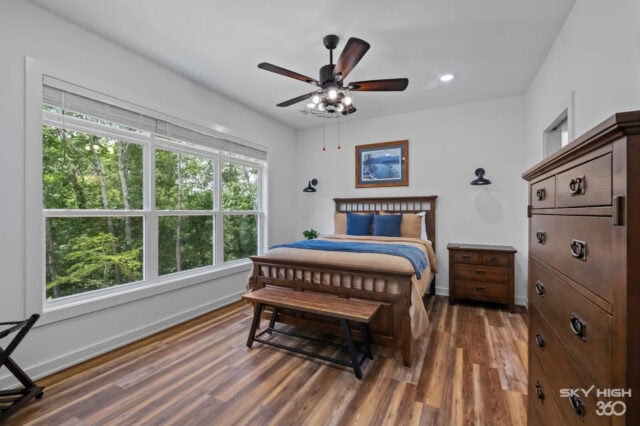Bright bedroom with large windows, wooden furniture, and scenic forest views in Bella Vista vacation.