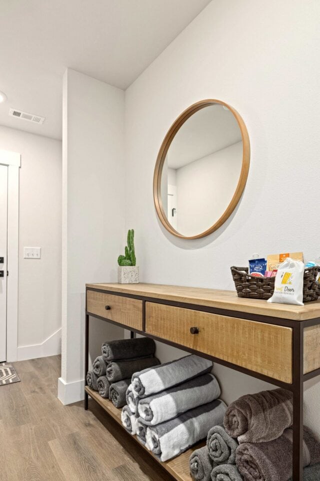Modern entryway with wooden console and round mirror in Bella Vista vacation rental.