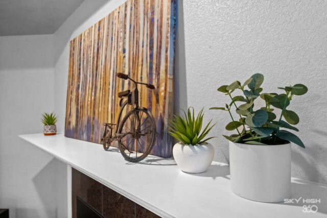 Decorative bicycle sculpture with potted plants on a white mantel in a cozy interior.