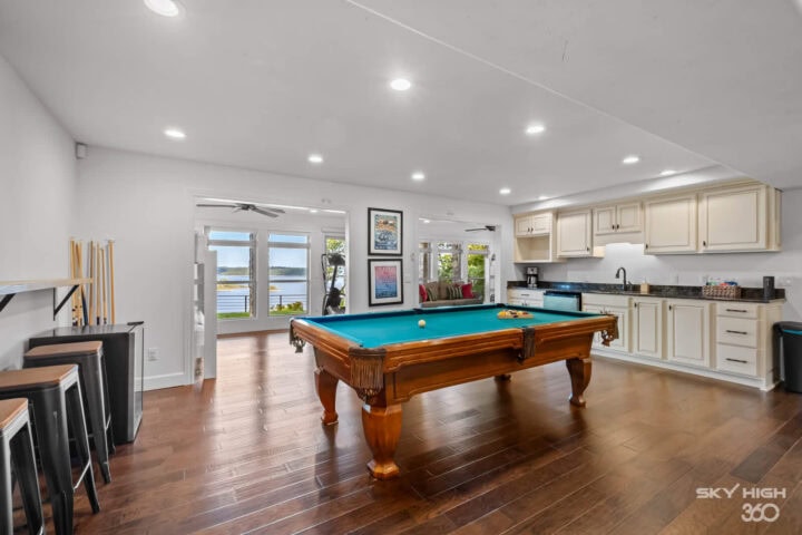 Spacious game room with pool table and lake views at Rivercliff Ridgehouse vacation rental in Rogers.
