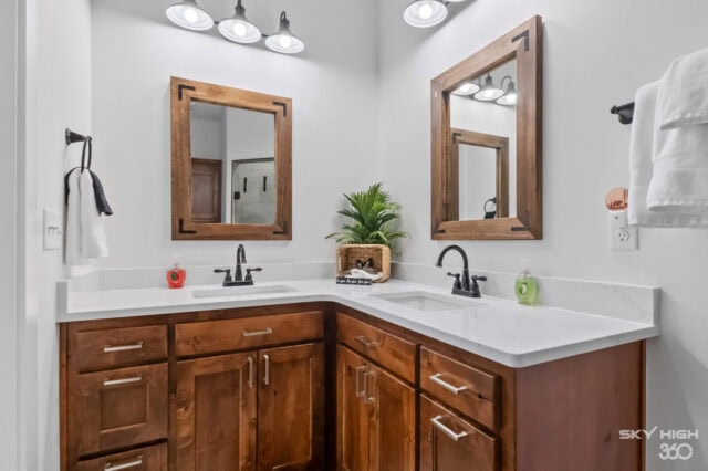 A comfortable bathroom with dual sinks, wooden cabinets, and modern lighting in the Black Bear Cabin.