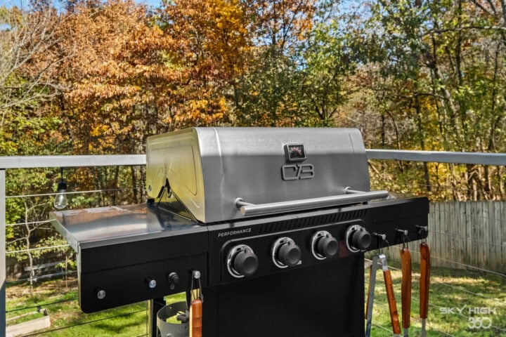 Grill on a deck with autumn trees in the background, perfect for outdoor cooking at Biker’s Basecamp.
