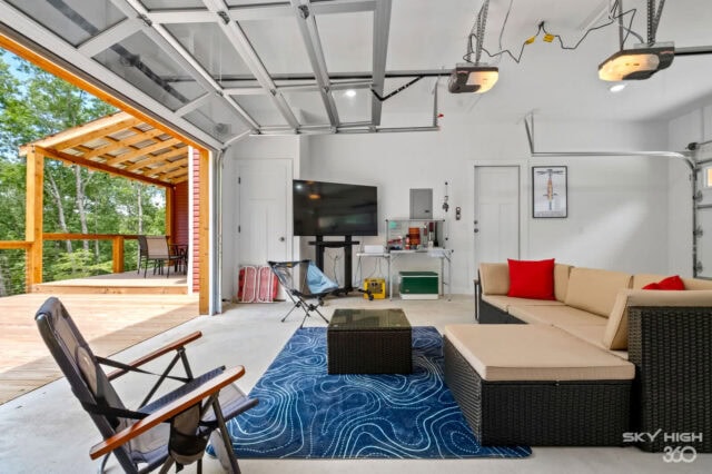 Cozy indoor living room with open garage door, outdoor deck, and mountain views at Black Bear Cabin.