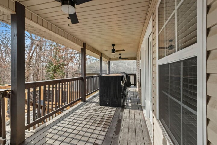 Cozy covered porch with outdoor seating and ceiling fans at The Witherby Woodland Retreat.