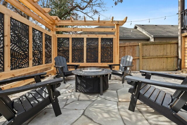 Relaxing outdoor patio with seating area and decorative privacy screens at The Witherby Woodland Ret.