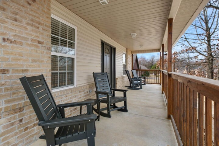Relaxing front porch with outdoor seating at The Witherby Woodland Retreat, Bella Vista Vacation Ren.