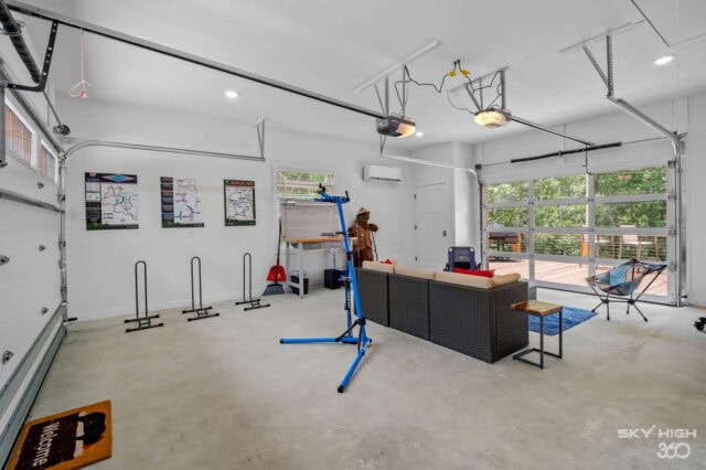 Spacious garage converted into a home gym with workout equipment and bright lighting.