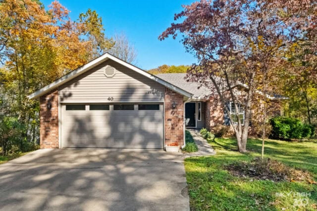 Bright suburban house with brick and siding exterior, surrounded by colorful autumn trees.