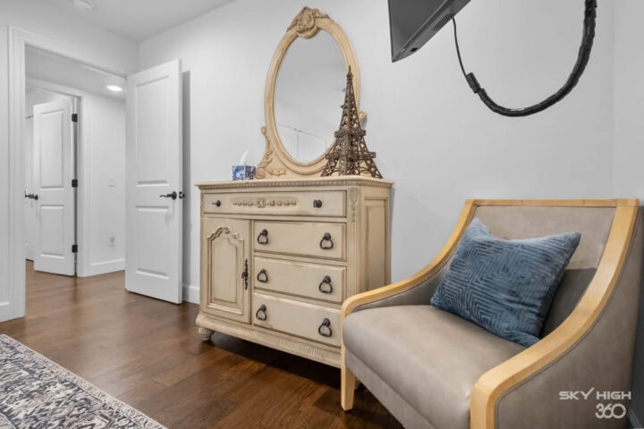 Elegant bedroom decor with vintage dresser and cozy armchair in a Rivercliff Ridgehouse vacation ren.