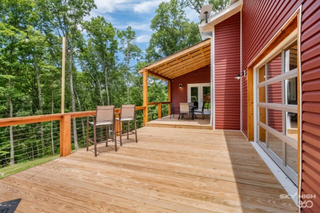 Relaxing outdoor deck at Black Bear Cabin with scenic forest views in Bella Vista.