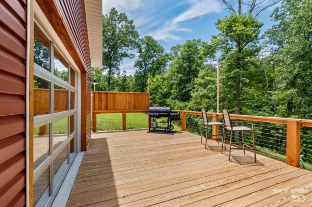 Spacious wooden deck at Black Bear Cabin with outdoor seating and scenic forest views.