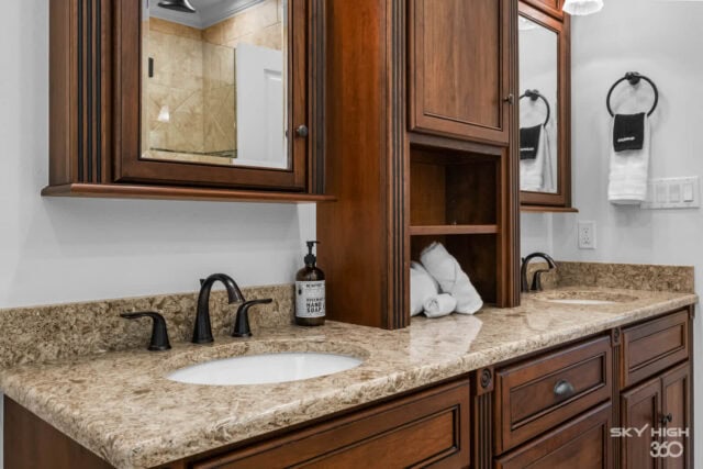 Relaxing bathroom vanity with dual sinks, granite countertops, and wooden cabinetry at Rivercliff Ri.