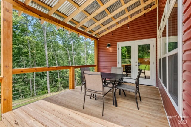 Cozy cabin porch with outdoor dining and forest views in Bella Vista.