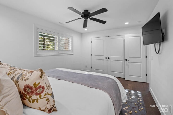 Relaxing bedroom with white walls, large window, and modern decor at Rivercliff Ridgehouse in Rogers.