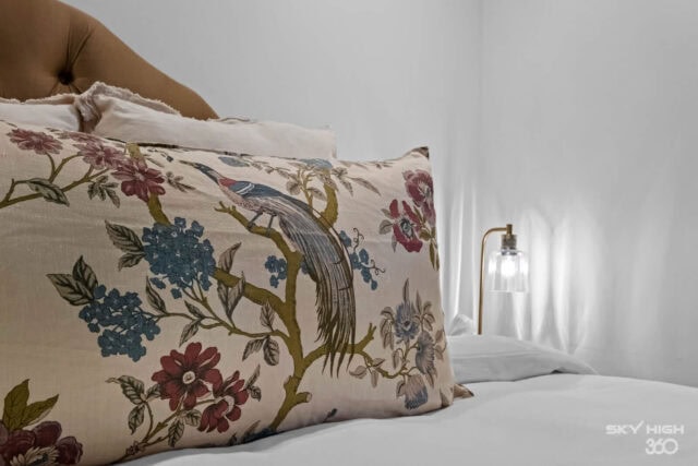 Relaxing bedroom with floral pillow and modern bedside lamp at Rivercliff Ridgehouse, Beaver Lake vi.