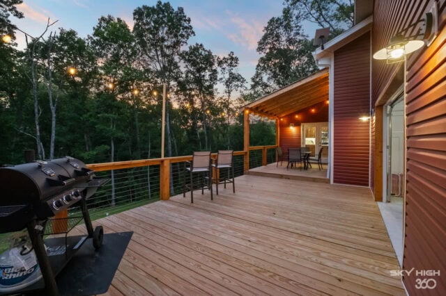 Spacious outdoor deck at Black Bear Cabin with seating and scenic forest views in Bella Vista.