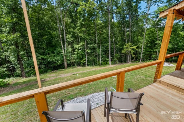 Wooden deck overlooking lush green forest at Black Bear Cabin vacation rental.