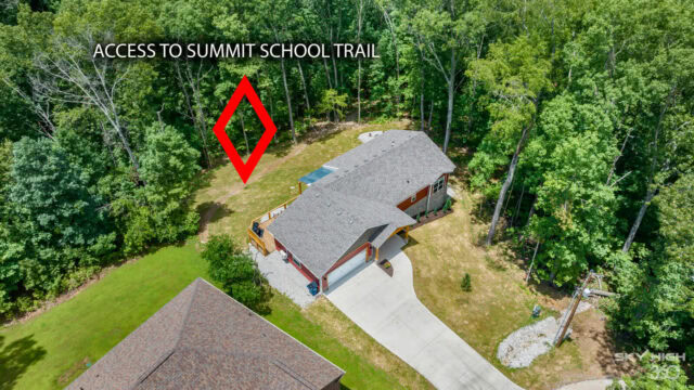 Secluded cabin with access to summit school trail in Bella Vista, surrounded by lush green trees.