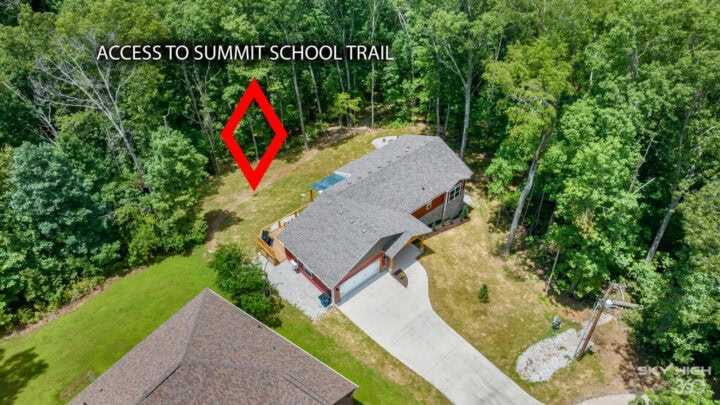 Secluded cabin with access to summit school trail in Bella Vista, surrounded by lush green trees.