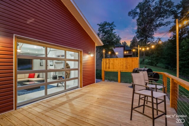 Modern outdoor deck at Black Bear Cabin with seating and string lights in Bella Vista.