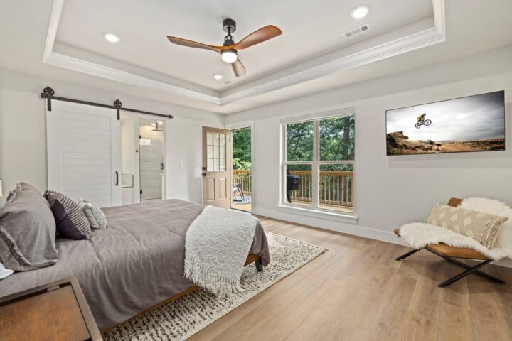 Relaxing bedroom with large windows, modern decor, and outdoor access at OZ Adventure Retreat near B.